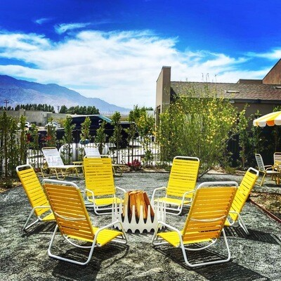 yellow chair outdoor gathering with white color wood burning Royalfire- modfire outdoor fireplace