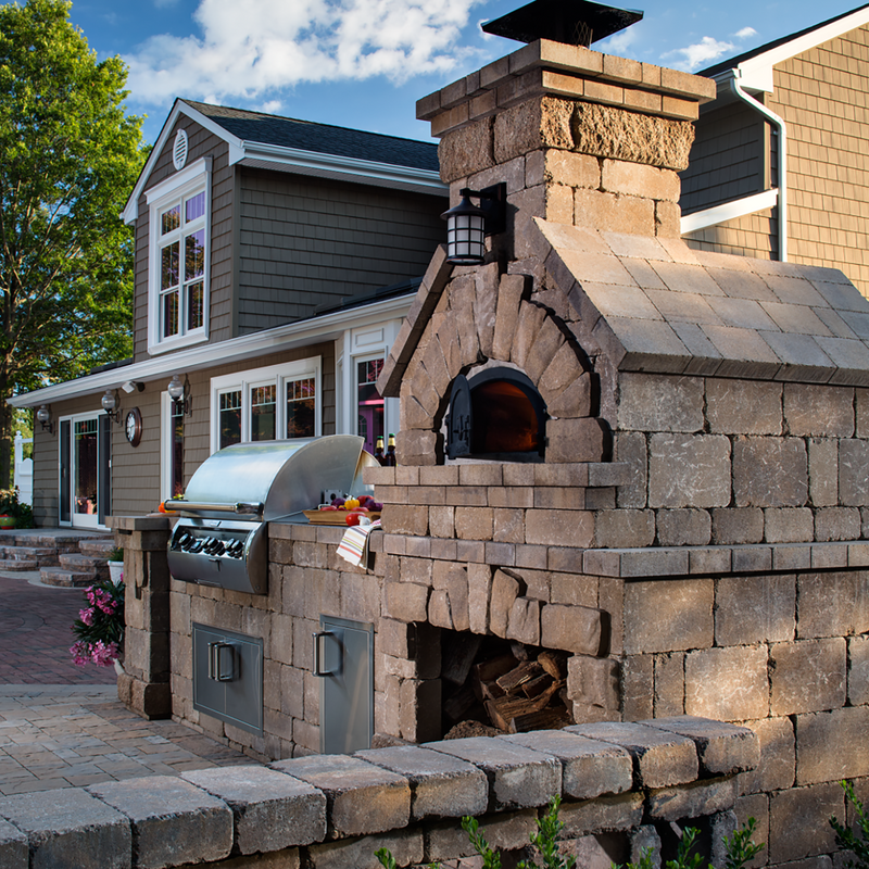 Brick outdoor Wood Gas Hybrid pizza oven with wood storage on a patio outdoor kitchen setup ready to make your perfect outdoor kitchen. CBO 750 Hybrid Pizza Oven, dual fuel pizza oven, outdoor wood fired pizza oven, natural gas pizza oven, DIY pizza oven kit, residential countertop pizza oven, Chicago Brick Oven, backyard pizza oven, outdoor kitchen pizza oven, hybrid pizza oven for home. Alfa Pizza Oven 3 pizze but better made in America with built in Gas BBQ LPG NG Pizza Oven Wood Burning Ooni Gozney