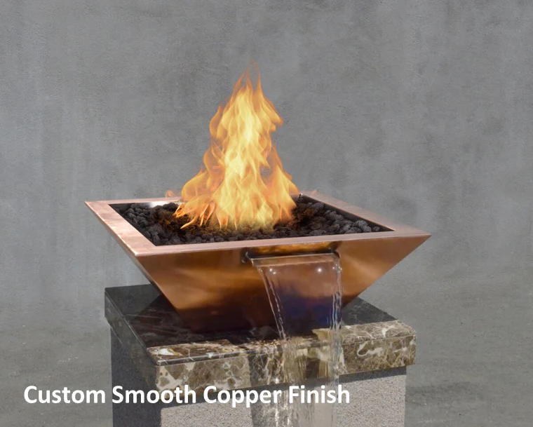 A square copper fire and water bowl with a custom smooth finish, featuring bright flames and a steady stream of water flowing over the edge, placed on a marble pedestal against a gray background.