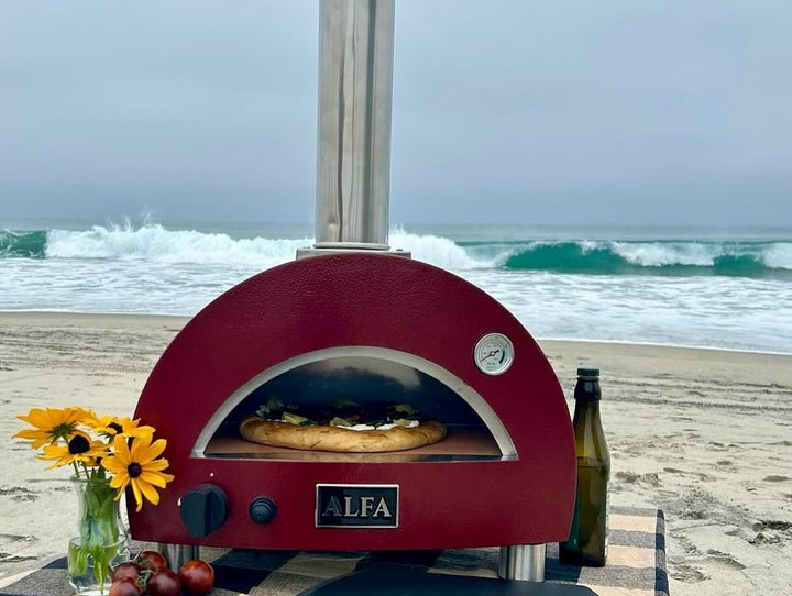 The Alfa Portable Pizza in its element cooking pizza on the beach