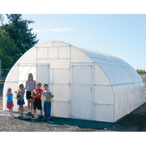 A smiling Woman and four children standing in front of Big Solexx 16' x 20' Commercial, Outdoor Greenhouse