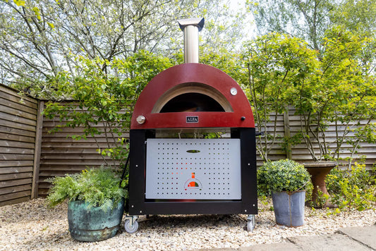 This is the Alfa 3 pizze with Base Stand - assembled and used by one of our customers- the 3 pizze has been perfect for her outdoor kitchen / Garden space. This Hybrid Pizza Oven is perfect for the backyard patio and entertaining area.  This is the Alfa Pizza Oven running on liquid propane with the base stand but can be used with the modular system and prep table. Photo by our Actual Customer In California -  Smokey Mountain Fireplaces- Thank you for Supporting our Small Family Business. Ship to your door 