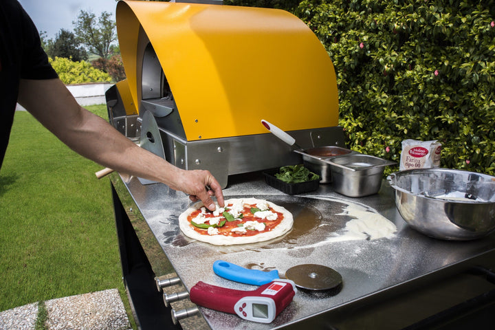 the 51" Alfa table, paired with the CIAO in yellow. Outdoor cooking at its very best gas or wood. you choose